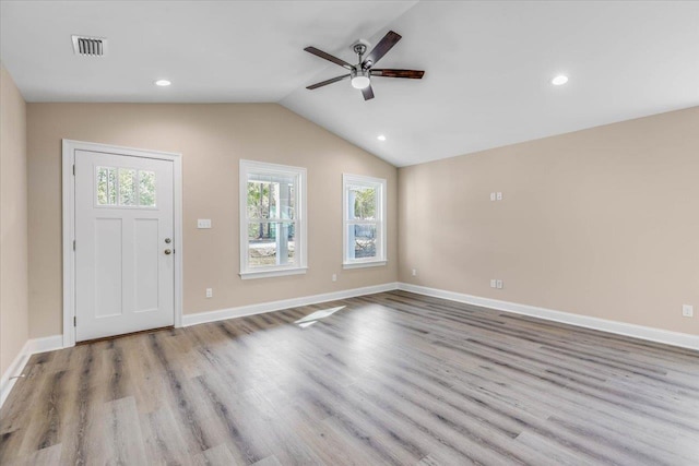 foyer entrance with lofted ceiling, ceiling fan, and light wood-type flooring