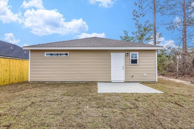 back of house with a yard, an outbuilding, and a patio area