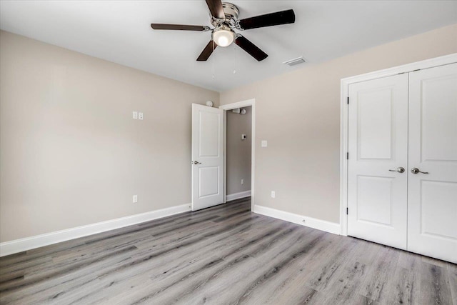 unfurnished bedroom with ceiling fan, light hardwood / wood-style floors, and a closet