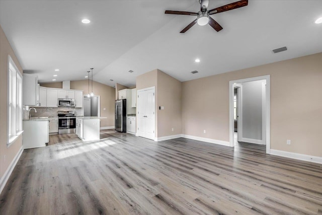 unfurnished living room with lofted ceiling, light hardwood / wood-style floors, and ceiling fan