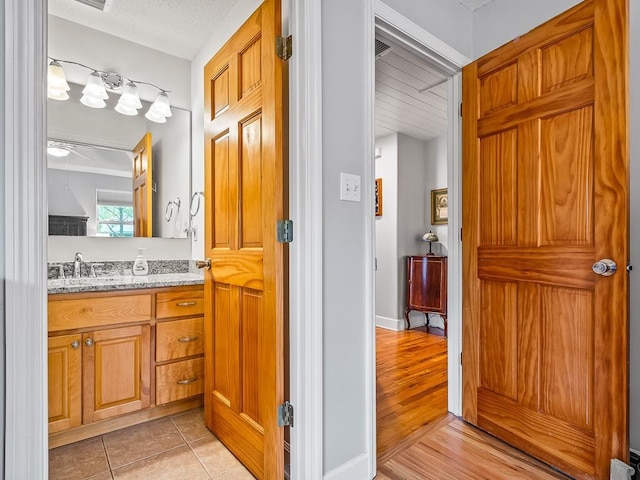 bathroom with tile patterned floors, vanity, and a textured ceiling