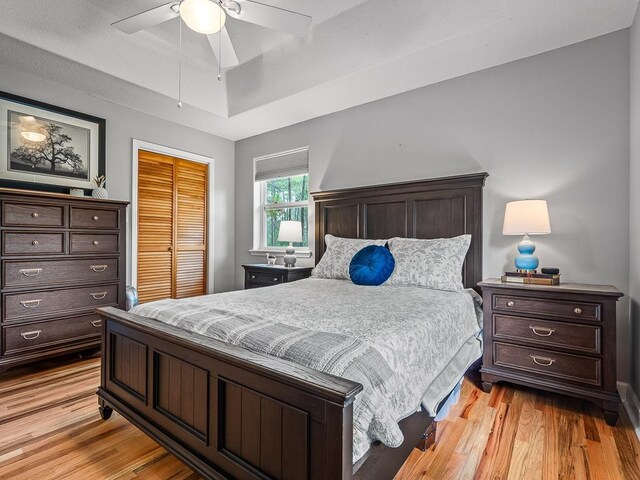 bedroom with light wood-type flooring, a closet, and ceiling fan