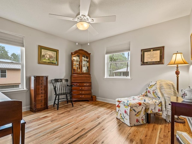 living area featuring light hardwood / wood-style flooring and ceiling fan