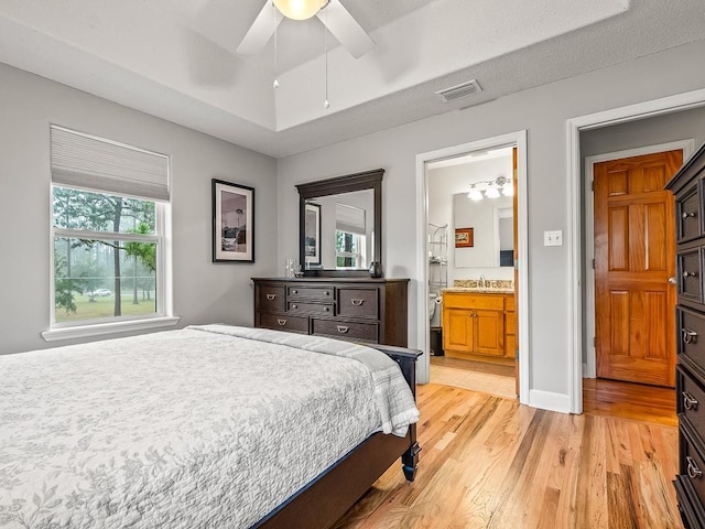 bedroom featuring connected bathroom, ceiling fan, and light hardwood / wood-style floors