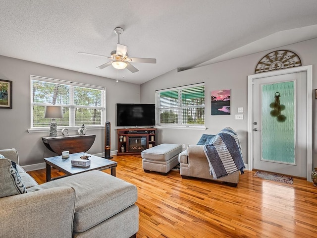 living room with plenty of natural light, light hardwood / wood-style floors, and vaulted ceiling