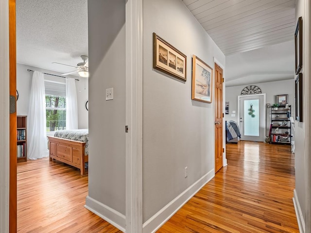 hallway featuring a textured ceiling and light hardwood / wood-style floors