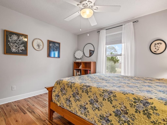 bedroom featuring hardwood / wood-style floors, a textured ceiling, and ceiling fan