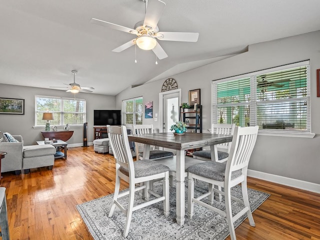 dining room with ceiling fan, lofted ceiling, and hardwood / wood-style flooring