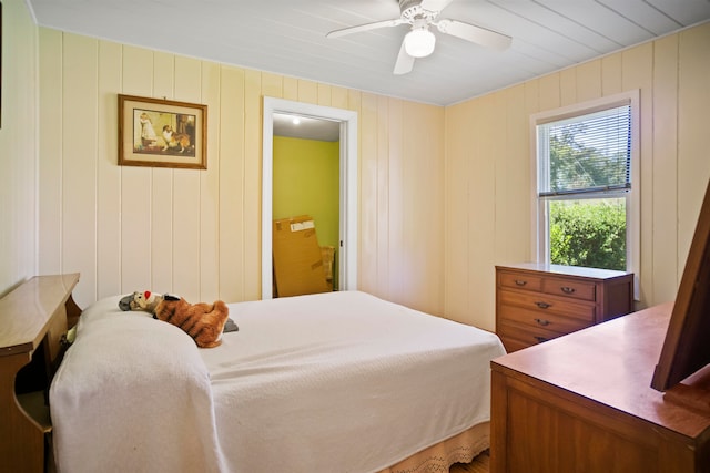 bedroom with wood walls and ceiling fan