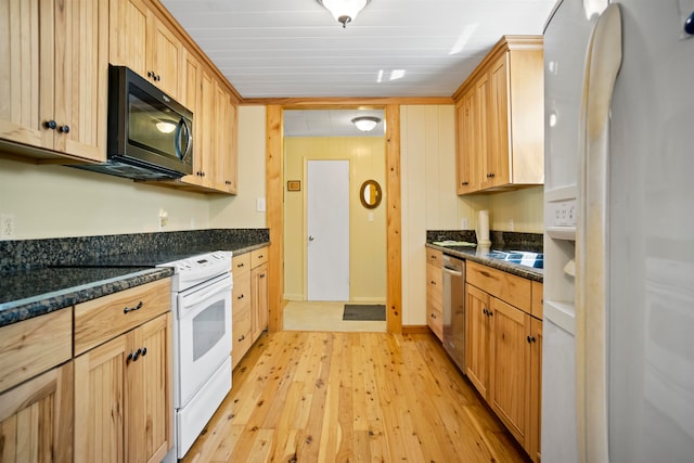 kitchen with light brown cabinetry, dark stone countertops, light wood-type flooring, and appliances with stainless steel finishes