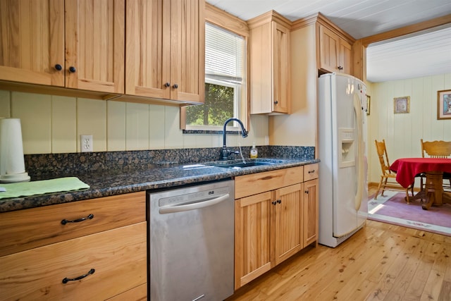 kitchen with dishwasher, white fridge with ice dispenser, dark stone counters, and light hardwood / wood-style floors