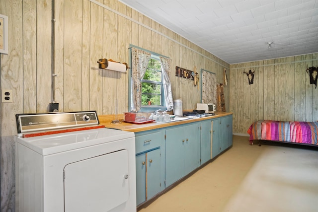 washroom featuring wood walls, washer / clothes dryer, and sink