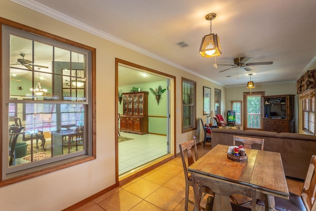 tiled dining room featuring ceiling fan with notable chandelier and ornamental molding