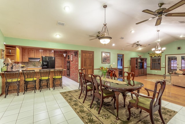 tiled dining space featuring vaulted ceiling and a notable chandelier