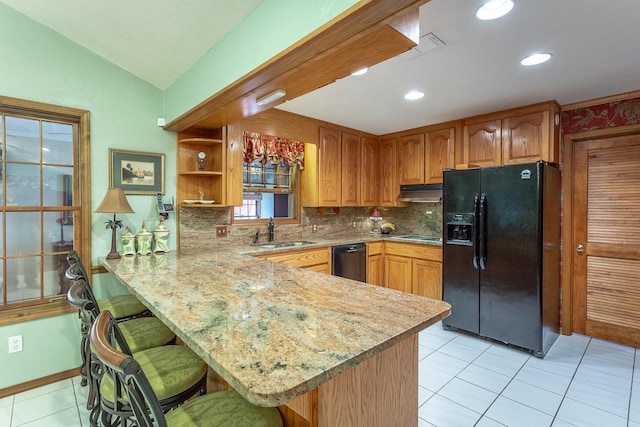 kitchen with kitchen peninsula, sink, vaulted ceiling, and black appliances