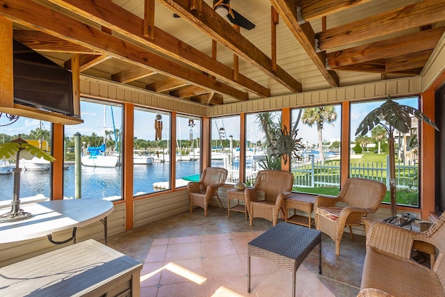 sunroom featuring beam ceiling, ceiling fan, and a healthy amount of sunlight