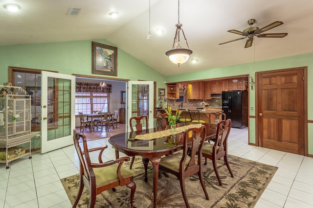 tiled dining space featuring ceiling fan, french doors, and lofted ceiling