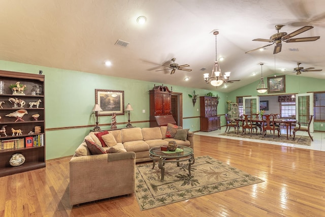 living room featuring light hardwood / wood-style flooring, vaulted ceiling, and a notable chandelier