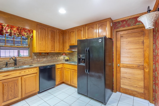 kitchen featuring black appliances, backsplash, light tile patterned floors, and sink