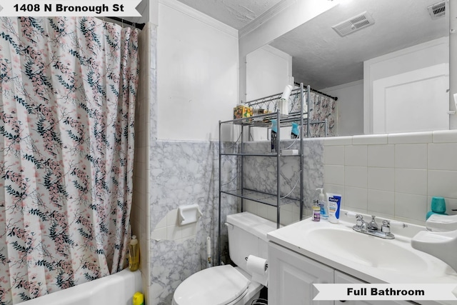 full bathroom with a textured ceiling, toilet, visible vents, and tile walls