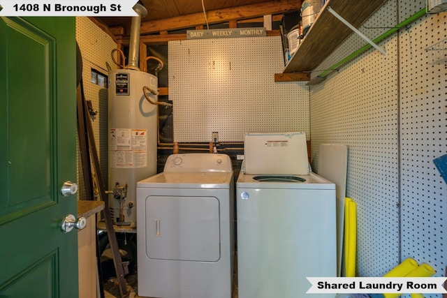 washroom featuring washing machine and dryer, gas water heater, and laundry area