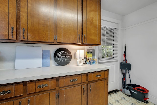 kitchen with light countertops, light floors, and brown cabinetry