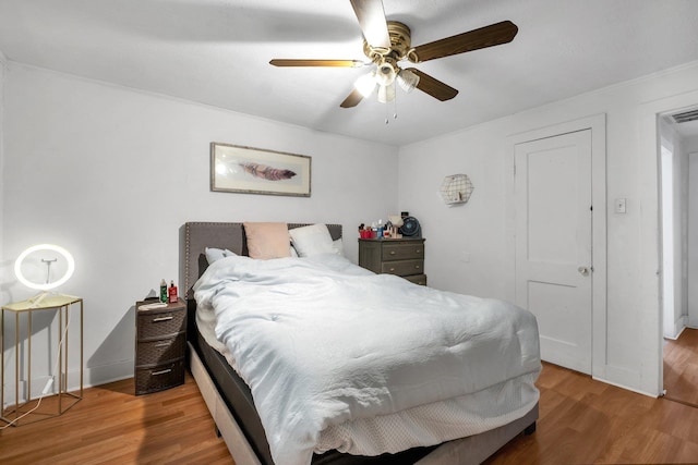 bedroom with visible vents, ceiling fan, baseboards, and wood finished floors