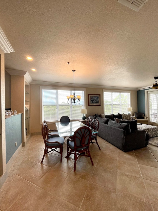 tiled dining room with a textured ceiling, an inviting chandelier, and crown molding