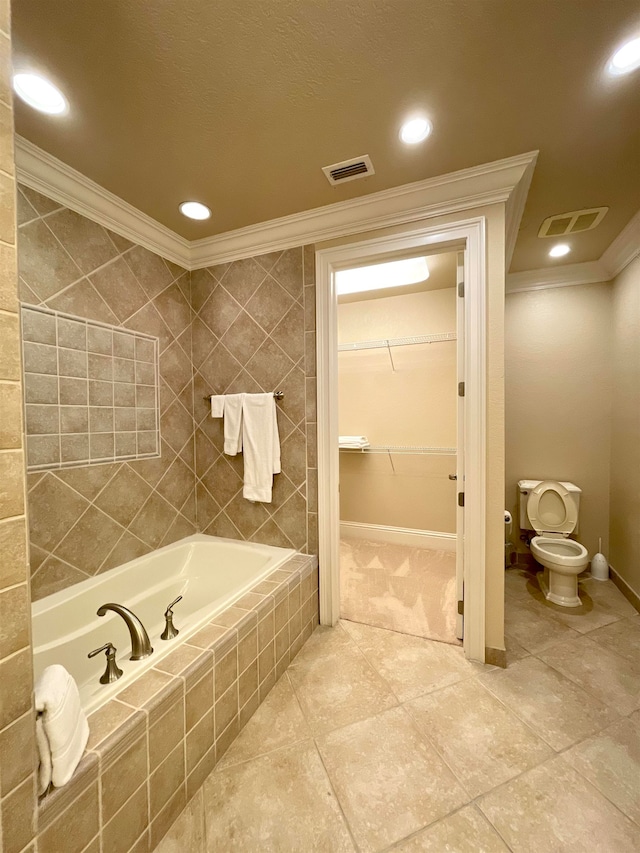 bathroom featuring toilet, tiled tub, tile patterned flooring, and crown molding