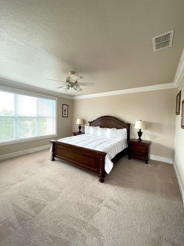 carpeted bedroom with ornamental molding, a textured ceiling, and ceiling fan