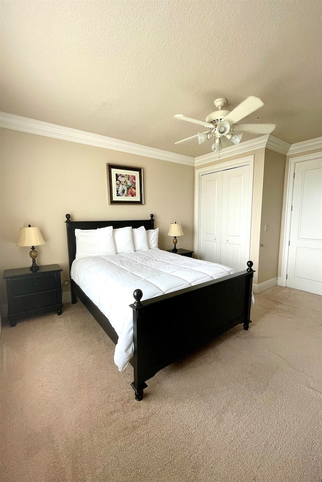 bedroom with ceiling fan, a textured ceiling, a closet, and carpet floors