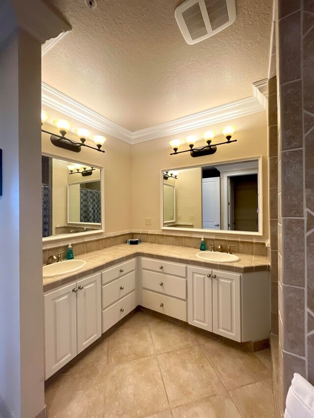 bathroom featuring vanity, a textured ceiling, tile patterned floors, and crown molding