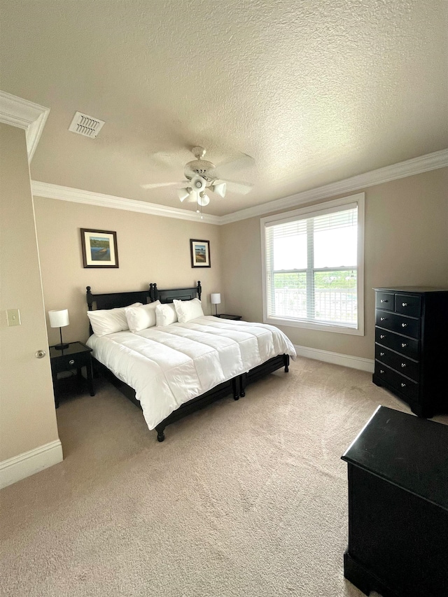 bedroom with ornamental molding, carpet, a textured ceiling, and ceiling fan