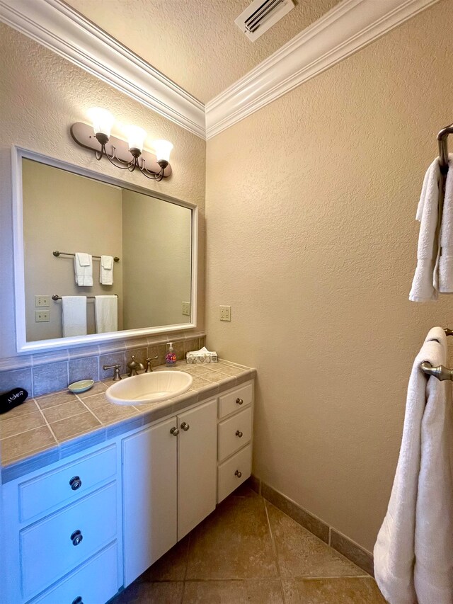 bathroom with vanity, tile patterned flooring, a textured ceiling, and ornamental molding