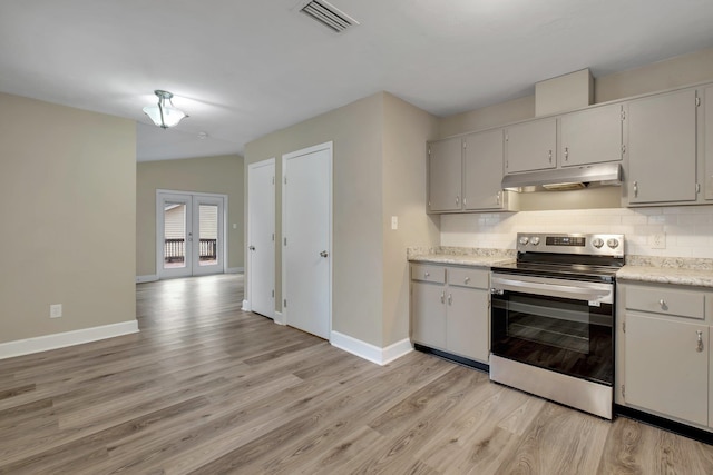 kitchen with tasteful backsplash, gray cabinetry, french doors, stainless steel electric range oven, and light hardwood / wood-style flooring