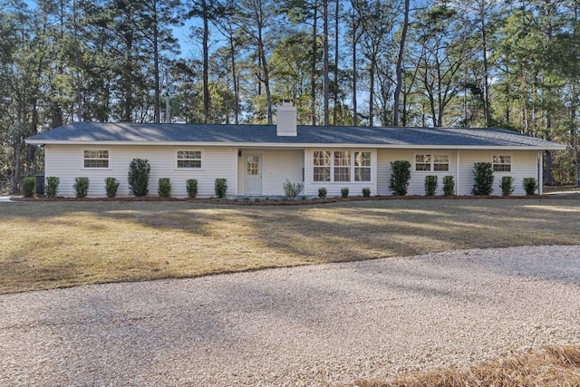 ranch-style home with a chimney and a front lawn