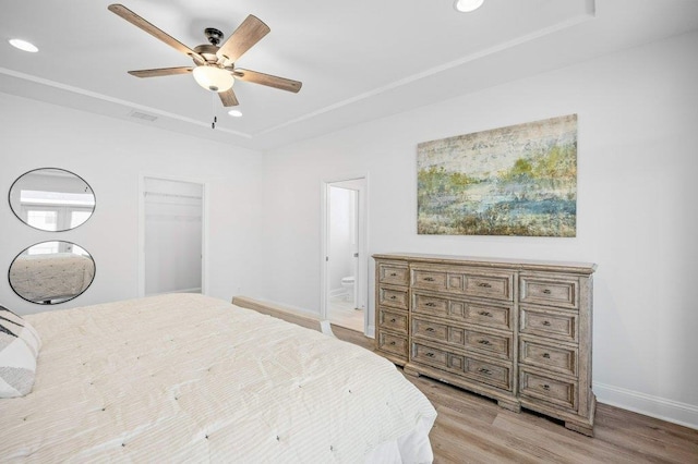 bedroom with light hardwood / wood-style flooring, ceiling fan, ensuite bath, and a closet