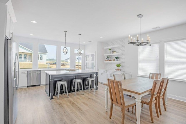 dining room with sink, an inviting chandelier, and light hardwood / wood-style flooring