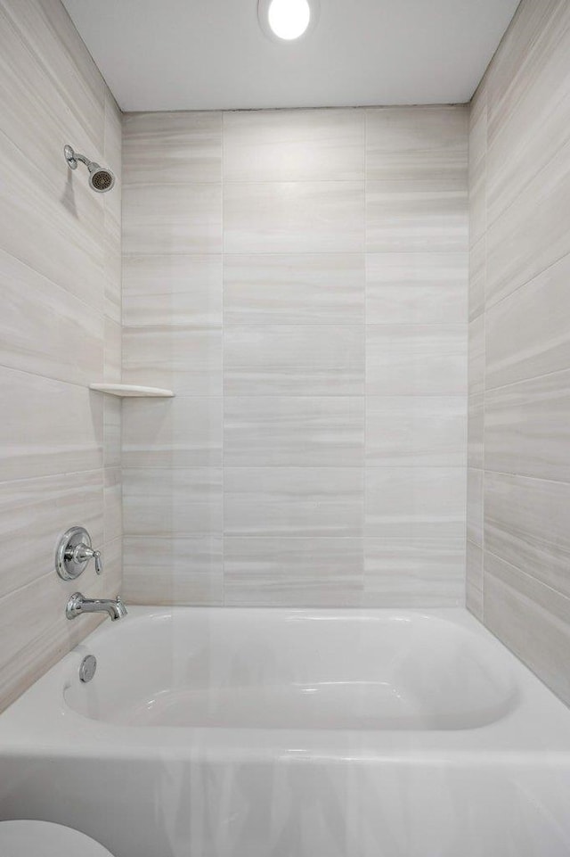 bathroom featuring toilet and shower / bathtub combination