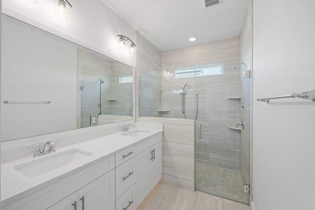 bathroom with walk in shower, vanity, and hardwood / wood-style floors