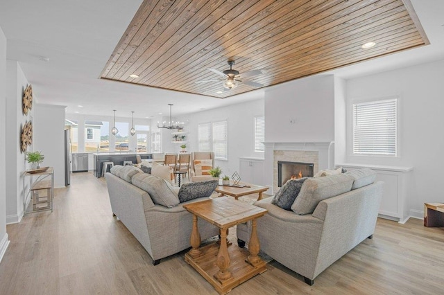 living room with wooden ceiling, a wealth of natural light, and light wood-type flooring