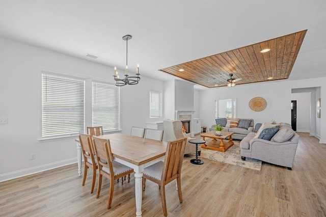 dining area with wooden ceiling, ceiling fan with notable chandelier, a healthy amount of sunlight, and light hardwood / wood-style flooring