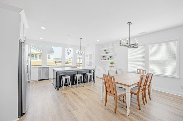 dining area featuring light hardwood / wood-style floors and a notable chandelier