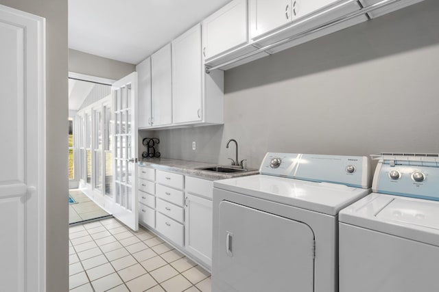 clothes washing area with cabinet space, light tile patterned flooring, a sink, and separate washer and dryer