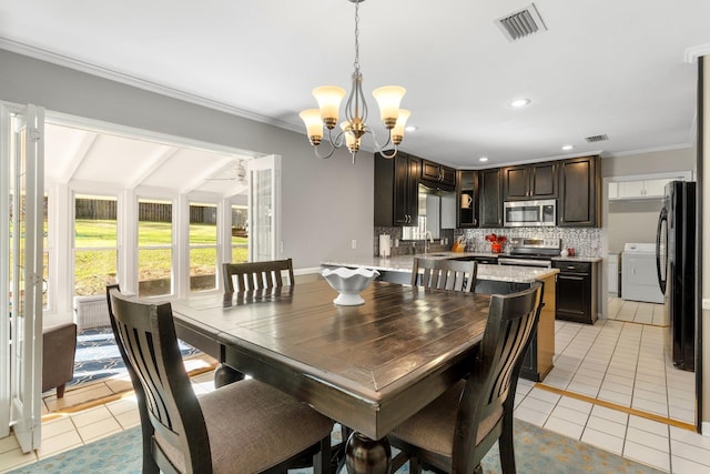 dining area featuring visible vents, crown molding, washer and clothes dryer, and light tile patterned floors