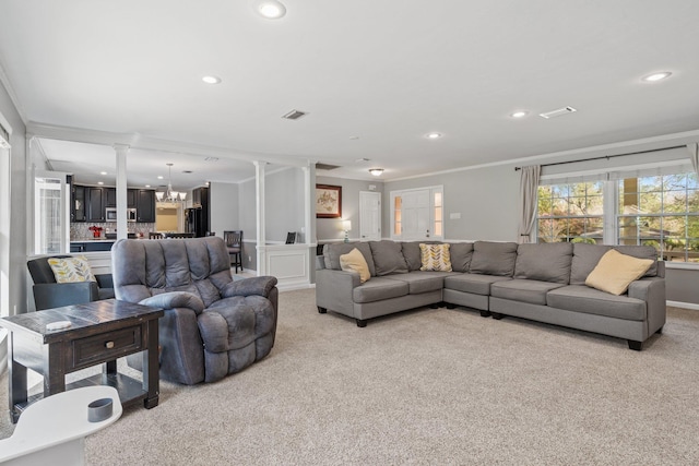 living area with decorative columns, recessed lighting, light colored carpet, visible vents, and a chandelier