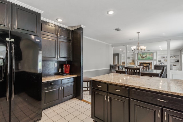 kitchen with light tile patterned flooring, crown molding, black fridge with ice dispenser, visible vents, and ornate columns