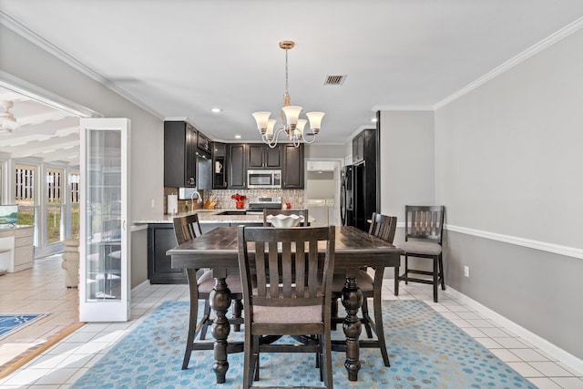 dining space featuring ornamental molding, light tile patterned flooring, visible vents, and a notable chandelier