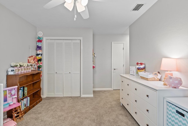 bedroom with a closet, visible vents, light carpet, ceiling fan, and baseboards