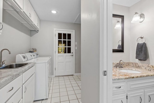 washroom with light tile patterned floors, cabinet space, a sink, and independent washer and dryer